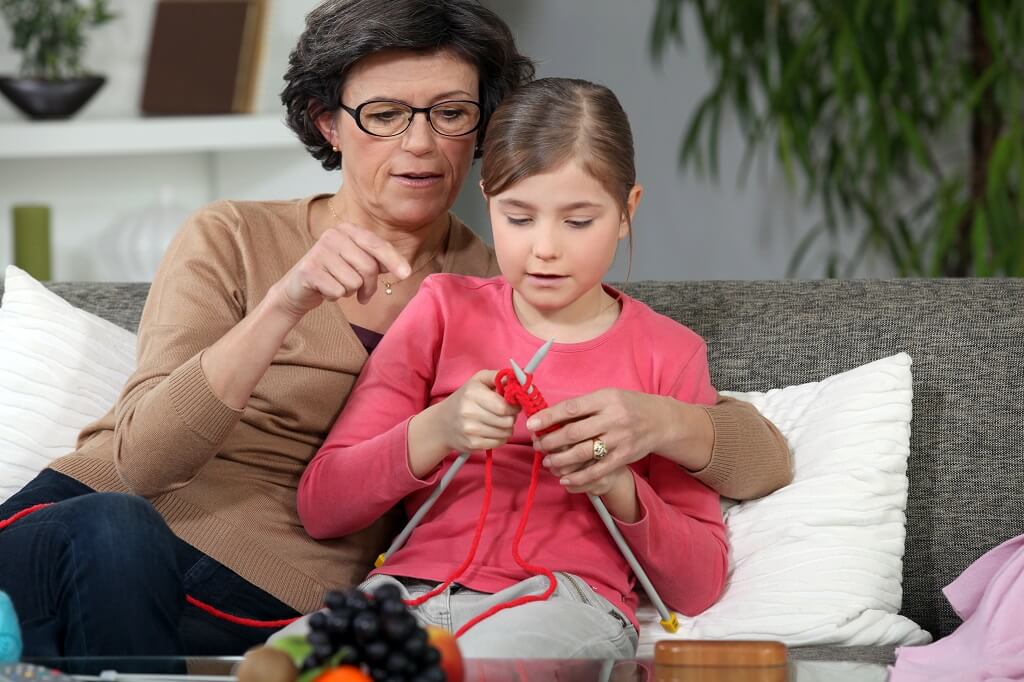Grandparent teaching grandchild to knit