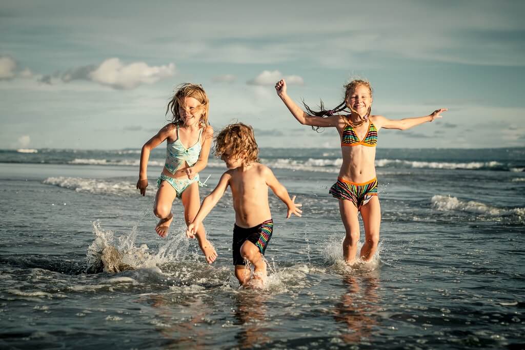Kids on the beach as part of a screen free summer holiday